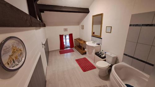 a bathroom with a sink and a toilet and a tub at Maison Saint Romain in Saulgond