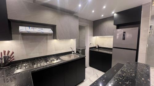 a kitchen with a sink and a refrigerator at كورنيش نيل معادي in Al Ma‘şarah