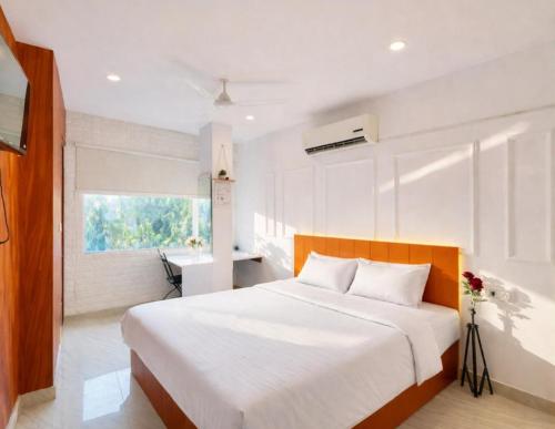 a bedroom with a large white bed and a window at The First Floor I Top Rated Boutique Homestay I Near Lekhraj Metro Lucknow in Lucknow