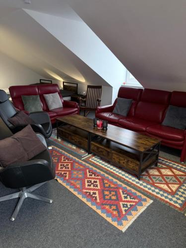 a living room with red furniture and a rug at Gemütliches City-Appartment in Wentorf bei Hamburg