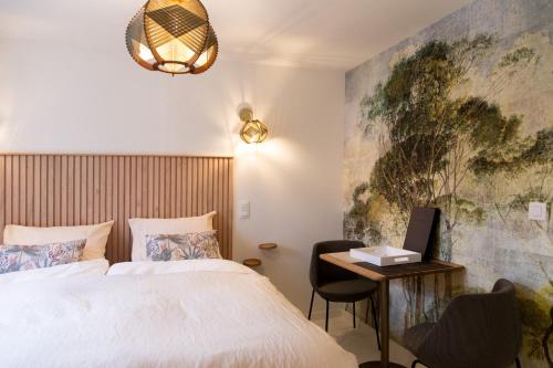 a bedroom with a bed and a desk with a laptop at Table Rase chambres d'hôtes, restaurant et weekend aux Thermes de Spa in Theux