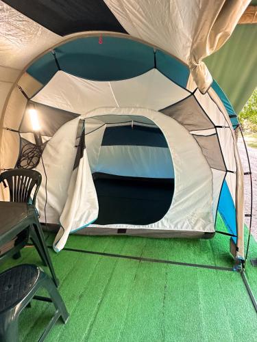 a tent is set up with a table and a chair at Ermida Gerês Camping in Ermida