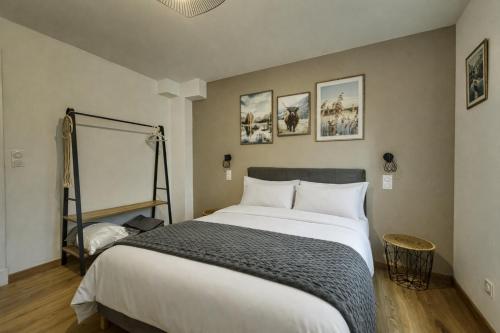a bedroom with a large white bed and pictures on the wall at Au Balcon de la Basilique in Boulogne-sur-Mer