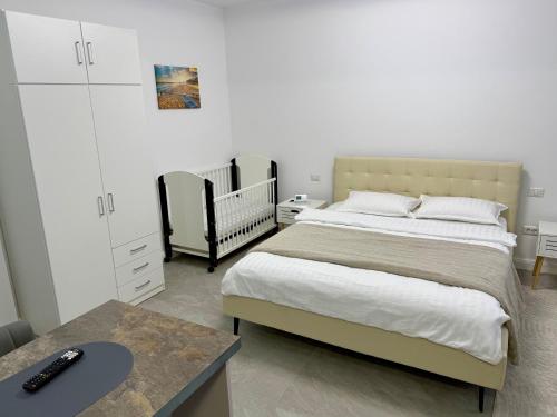 a bedroom with a bed and a table and a crib at visitor's house 2 in Rădăuţi