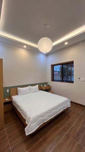 a bedroom with a large white bed in a room at Chài Beach Homestay in Ninh Hải