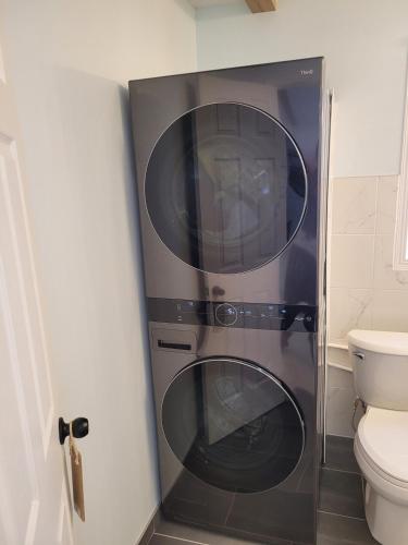 two washer and dryer in a bathroom next to a toilet at Le Chalet du Domaine Gourmand in Thetford Mines