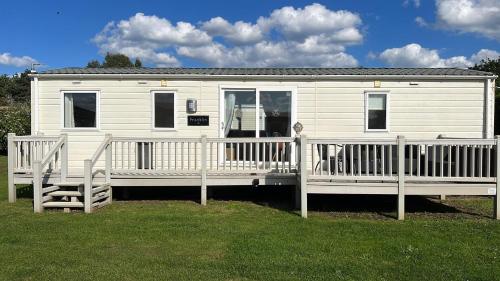 a white caravan with a porch and a wooden deck at Burgh Castle 3-Bed Haven: Near Norfolk Broads in Belton