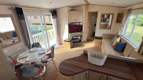 a living room with a couch and a table at Burgh Castle 3-Bed Haven: Near Norfolk Broads in Belton