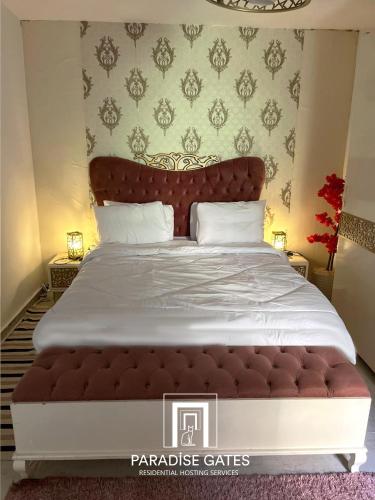a bedroom with a large bed with a large white bedspread at Paradise Gates Madinaty in Madinaty