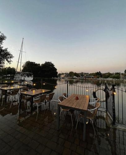 a group of tables and chairs next to a body of water at The Steam Packet Inn in Totnes