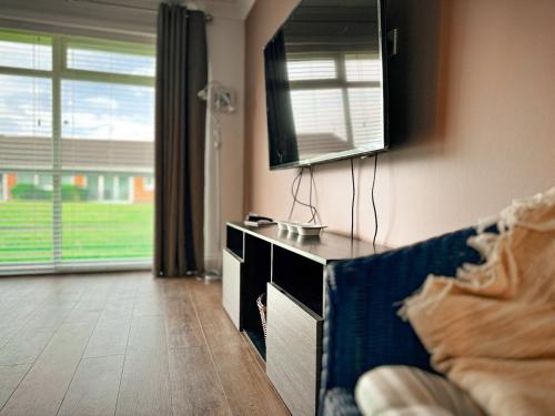 a living room with a tv and a couch at Dog Friendly Kessingland Chalet | Coastal Retreat in Kessingland