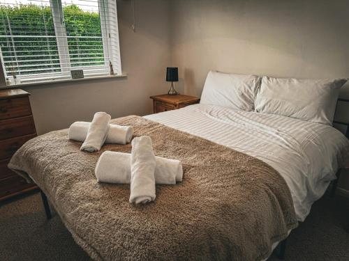 a bedroom with a large bed with towels on it at Dog Friendly Kessingland Chalet | Coastal Retreat in Kessingland