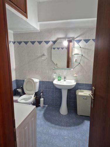 a bathroom with a sink and a toilet and a mirror at Sea View Artaki Apartment in Nea Artaki