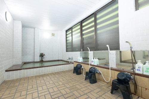 a bathroom with a tub and two sinks and a shower at 苗場ロッヂ丘 in Yuzawa