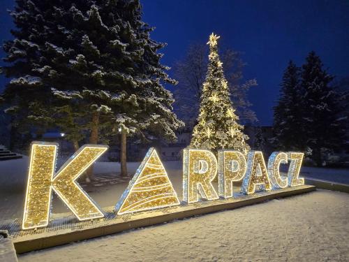ein Schild mit der Aufschrift „Kappaq“ vor einem Weihnachtsbaum in der Unterkunft Apartament Sudecki in Karpacz