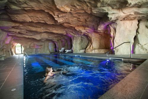 a woman swimming in a pool in a cave at Castello di Guarene in Guarene