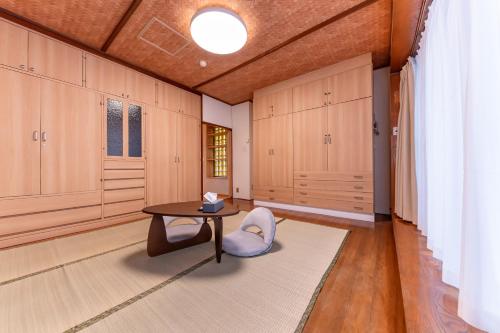 a room with a table and a chair and cabinets at Kawasaki Central House in Kawasaki