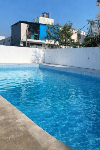 a swimming pool with blue water in front of a building at Rajstar Resort in Murthal