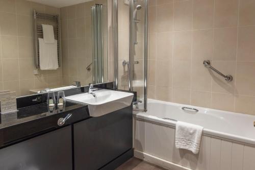 a bathroom with a sink and a bath tub at Kings Court Hotel Alcester, BW Signature Collection in Stratford-upon-Avon