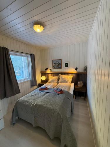 a bedroom with a bed and a window at Modern waterfront rorbu with terrace and stunning sea view - free parking in Stamsund