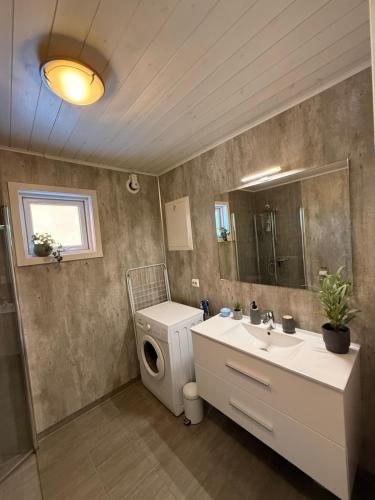 a bathroom with a sink and a toilet and a mirror at Modern waterfront rorbu with terrace and stunning sea view - free parking in Stamsund