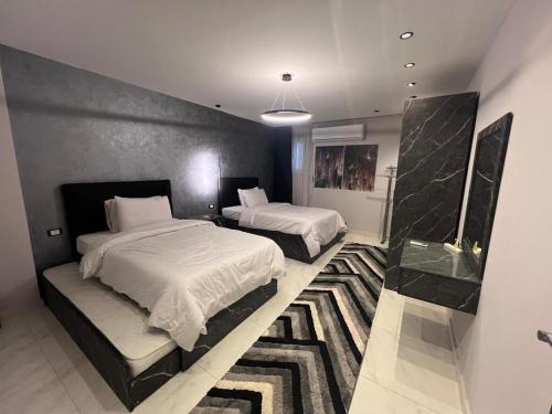 a bedroom with two beds and a rug at كورنيش نيل معادي in Al Ma‘şarah