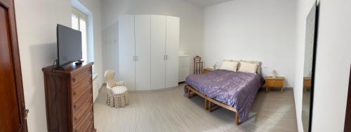 a bedroom with a bed and a dresser and a tv at Cà Turi Sarzana in Sarzana