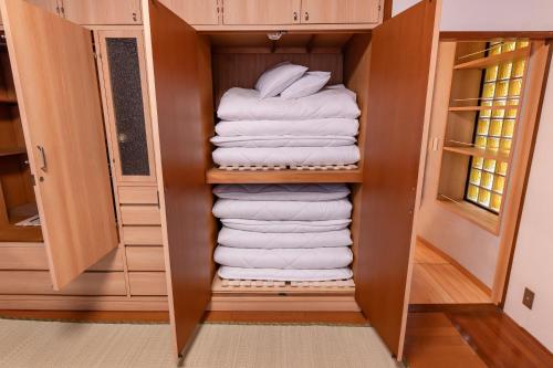 a closet with a stack of white towels at Kawasaki Central House in Kawasaki