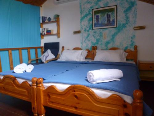 a bedroom with a wooden bed with towels on it at Athina Apartments in Arillas