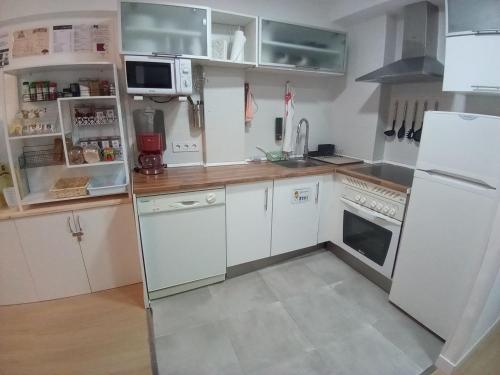 a kitchen with white appliances and white cabinets at MERINDADES AMAZUL CORZO - Apartamento Turístico - Medina de Pomar in Medina de Pomar