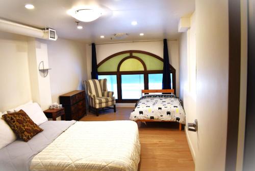 a bedroom with a bed and a chair and a window at Hôtel particulier du marché in Quebec City