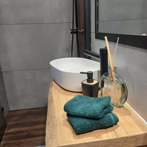 a bathroom with a sink and two towels on a table at Zacisze Częstkowo in Częstkowo