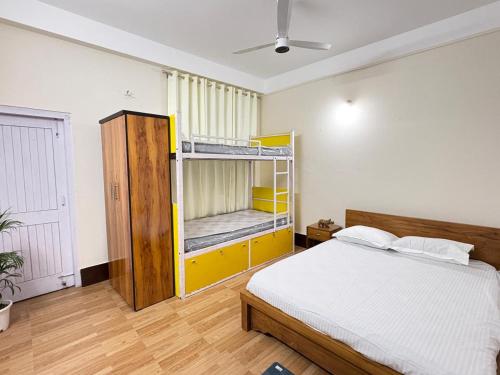 a bedroom with a bed and bunk beds in it at Yaro Backpackers Hostel in Guwahati