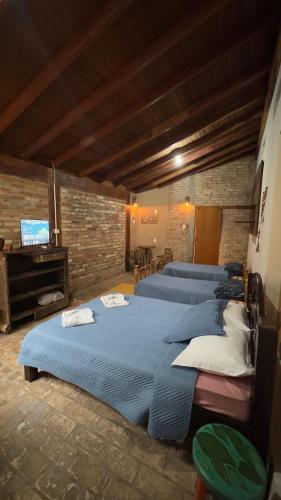 a group of beds in a room with a piano at HOTEL POUSADA MACHADO in Frutal