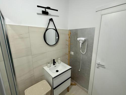 a bathroom with a sink and a mirror and a shower at visitor's house 4 in Rădăuţi