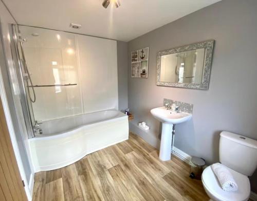 a bathroom with a tub and a sink and a toilet at Mill Lane Holiday Cottage -Bath in Bath