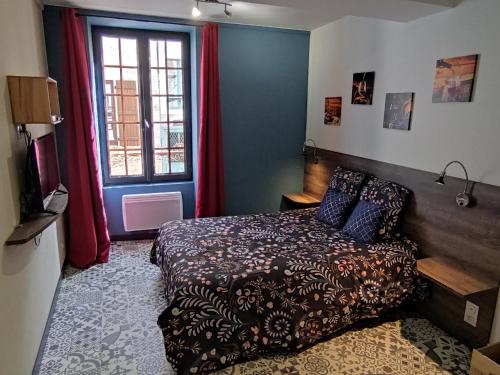 a bedroom with a bed in front of a window at La Belle vigne - Chablis Centre in Chablis