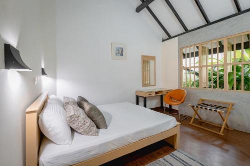 a bedroom with a bed and a desk and a window at Harmony Hills Boutique Villa in Ella