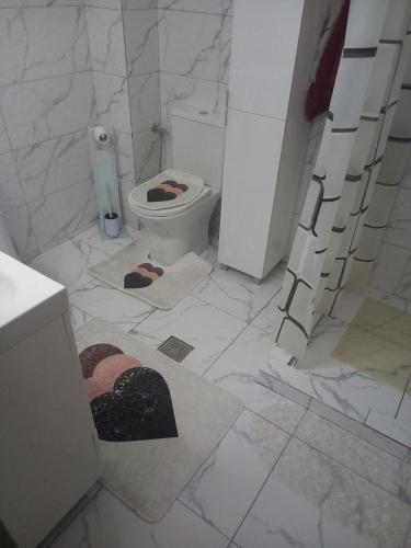 a white bathroom with a toilet and a sink at Căsuța din deal in Tranisu