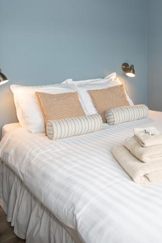 a white bed with pillows and towels on it at Vakantiewoning Conterdijk 13 in Koksijde