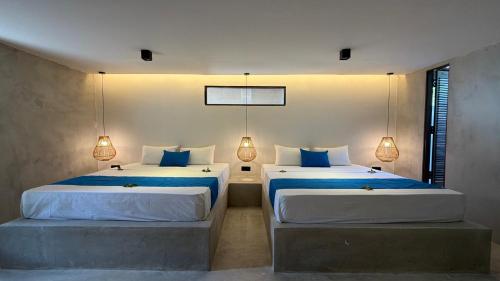 a bedroom with two beds with blue and white sheets at Three Tree Villa By Habarana in Habarana