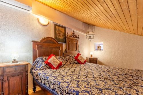 a bedroom with a bed with red pillows on it at Antique House Orlec in Orlec