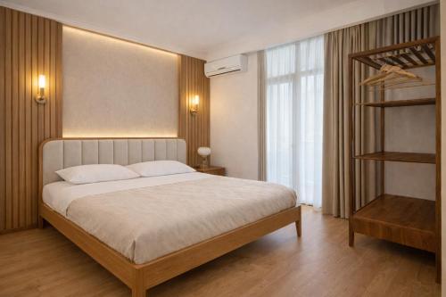 a bedroom with a large bed and a book shelf at City Heart Apartment in Tbilisi City