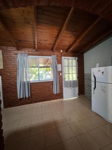 an empty room with a refrigerator and a window at Náutico Apart Hotel in Chascomús
