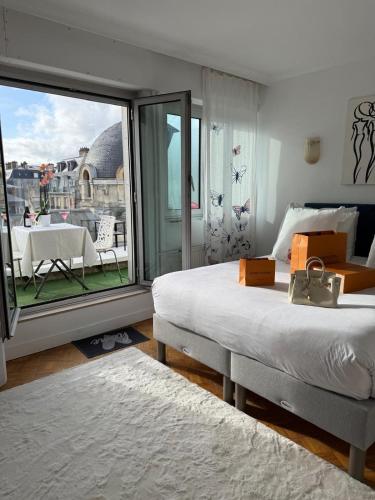 une chambre avec un lit et une grande fenêtre dans l'établissement Pépite Tour Eiffel, à Paris