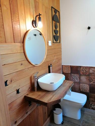 a bathroom with a sink and a mirror and a toilet at Salga Lodge in Angra do Heroísmo