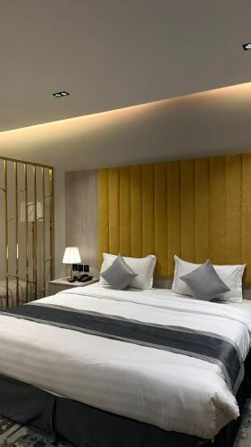 a large bed with white pillows in a bedroom at Al Seef Hotel in Al-ʿUla