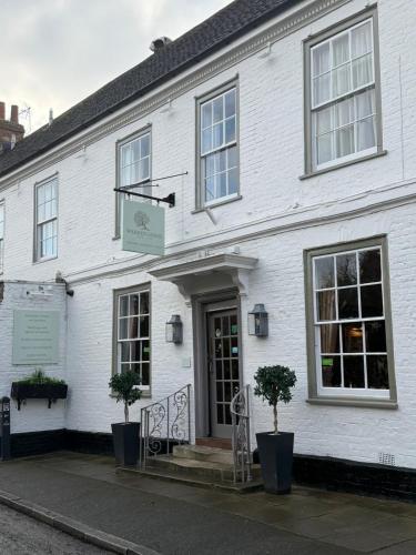 a white building with trees in front of it at Warren Lodge in Shepperton