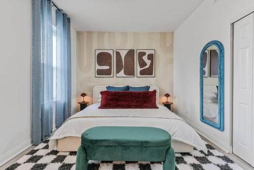 a bedroom with a bed and a green stool at Abstract Haven | Stylish 1BR by Tower Grove in Saint Louis