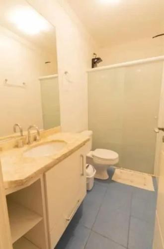 a bathroom with a sink and a toilet at Casa de temporada com piscina in Peruíbe